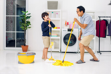 Father teaching asian kid little boy son having fun doing household chores cleaning and washing...