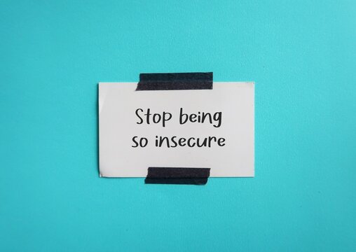 Note stick on blue wall STOP BEING SO INSECURE, self reminder to stop protecting yourself from being discomfort with uncertainty or lack of confidence, boost self-esteem and self-worth
