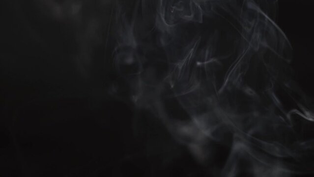 Slow motion shot of smoke or fog on the black background. Underwater smoke element. Abstract white smoke in slow motion on black background. 