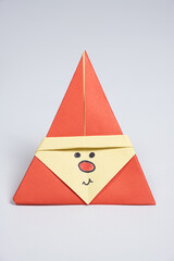 Christmas origami Santa Claus paper on a white background, DIY for the New Year