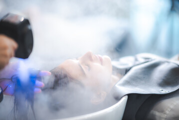 Young woman pampering herself at salon with hair spa, hair cut and hair wash with steam in salon