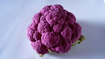 Whole violet cauliflower on the white background, isolated, frontal view.