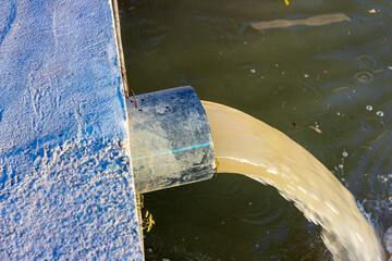 Wastewater sewage pipe dumps the dirty contaminated water into the river. Water pollution,...