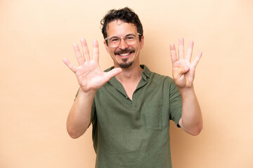 Young caucasian man isolated on beige background counting nine with fingers