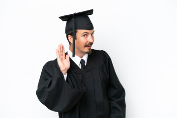 Young university graduate man isolated on white background listening to something by putting hand on the ear