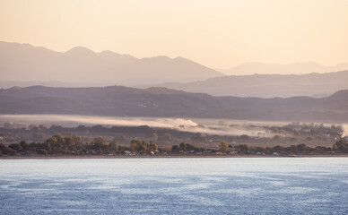 Residential Homes by the beach on Ionian Sea in a small touristic Town. Katakolo, Greece. Twilight Sunrise Sky.