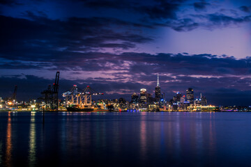 Fototapeta na wymiar Bright lights of Auckland downtown at night. Dramatic view over Auckland City from North Shore