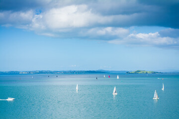 Obraz premium Small sailing boats scattered over calm waters of Auckland Harbour on a glorious winter day. North Island, New Zealand