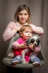 Fototapeta na wymiar A beautiful young mother with a little daughter is photographed in a home studio.