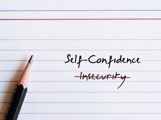 Pencil writing on note paper INSECURITY, replaced with SELF CONFIDENCE - to overcome being insecure...