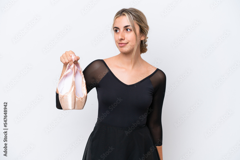 Wall mural Young caucasian woman practicing ballet isolated on white background looking to the side