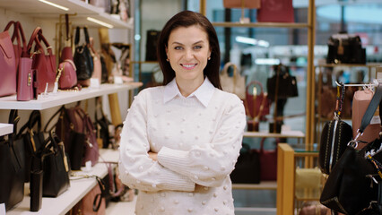 Amazing looking supervisor woman with a large smile looking straight to the camera and crossing hands in the accessories shop