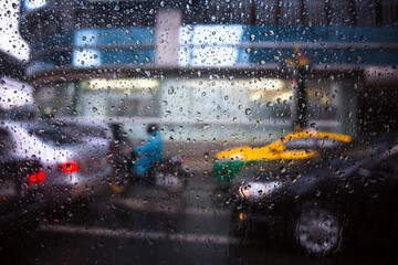 raining drops on the car window in the traffic jam city