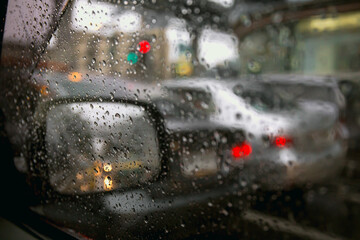 raining drops on the car window in the traffic jam city