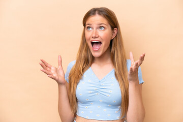 Young caucasian woman isolated on beige background with surprise facial expression