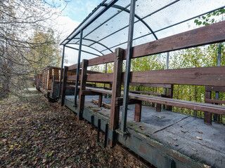 Old narrow track production train resting on the rails in autumn countryside