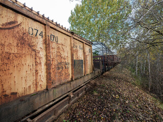 Obraz premium Old narrow track production train resting on the rails in autumn countryside