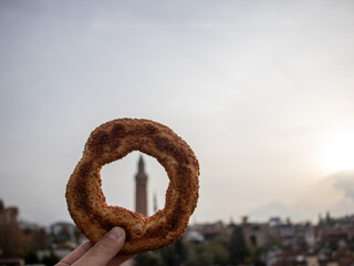 Traditional  simit bagel street food snack at the background of Yivli Minaret, Travel and Snack Concept , Yivli minaret is one of the main architectural landmarks of the old city of Antalya.