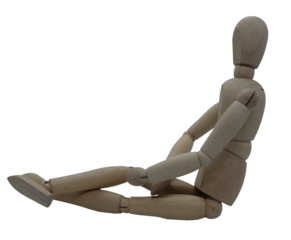 Wooden jointed figure sitting on ground with legs crossed and hands in lap