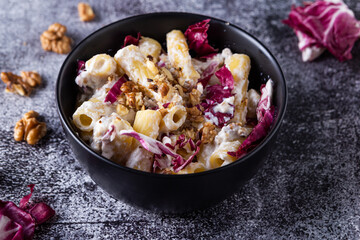 Creamy pasta with ricotta, walnuts and radish. Vegetarian macaroni pasta with ricotta and radicchio.