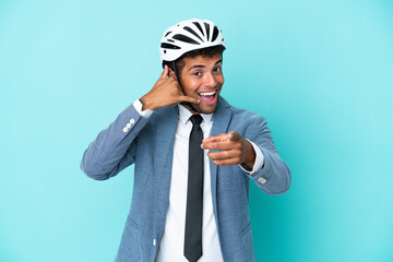 Young business Brazilian man with bike helmet isolated on blue background making phone gesture and...