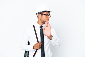 Architect brazilian man with helmet and holding blueprints making stop gesture and disappointed
