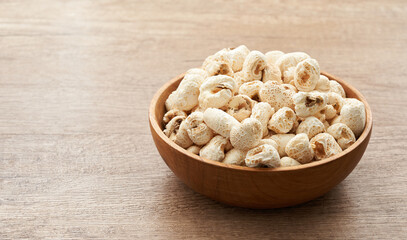 traditional Korean popcorn or Gangnange in wood bowl on wooden table background                                                     