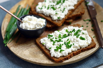 Open sandwiches with rye bread and white cottage cheese with green onions. Healthy breakfast or...