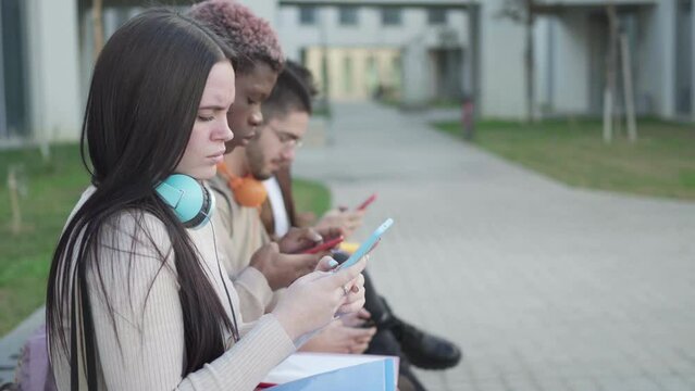 a group of college students looking at their smartphone, addicted to the phone
