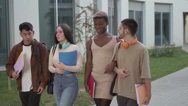 a group of college students walk around the university campus talking about exams