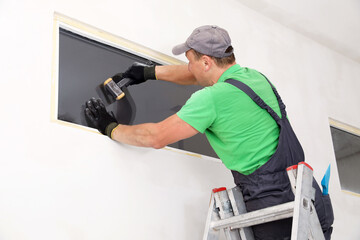 Fototapeta premium Worker in uniform installing double glazing window indoors