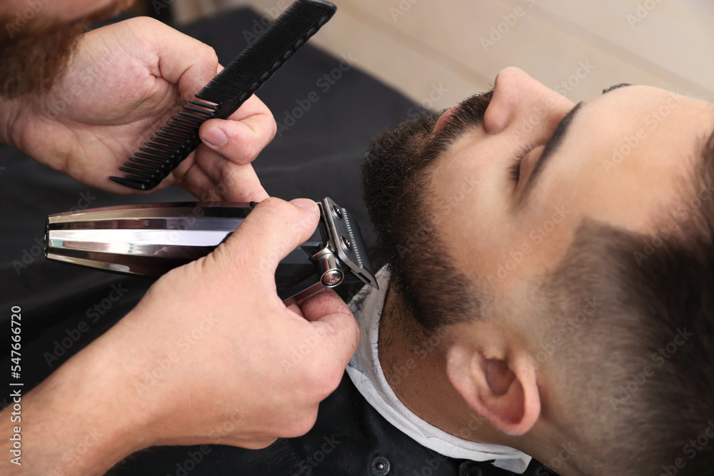 Poster Professional hairdresser working with client in barbershop, closeup