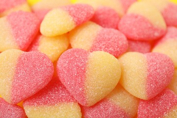 Many tasty jelly candies in shape of hearts as background, closeup