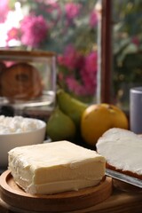 Tasty homemade butter, bread slices and tea on wooden table