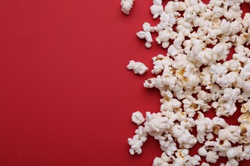 Tasty popcorn on red background, flat lay. Space for text