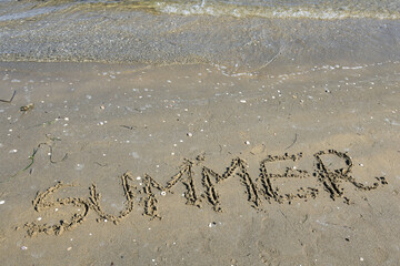 capital letters text SUMMER on the sand of the beach
