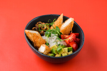 Asian food rice with breaded tofu cheese, champignons, avocado, cherry tomatoes, decorated with green peas on a red background.