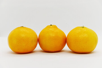 Ripe juicy tangerines lie on a white background