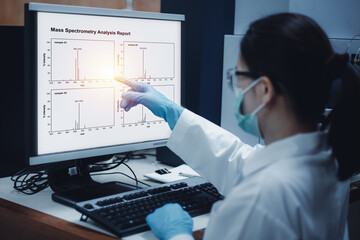 Scientist woman indicated mass spectrometry results from analysis differences of samples shown on the computer in the laboratory. - obrazy, fototapety, plakaty