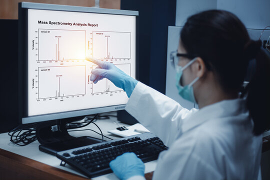 Scientist woman indicated mass spectrometry results from analysis differences of samples shown on the computer in the laboratory.