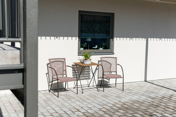 Little table and chairs on the veranda on a sunny day, relaxing zone. Cozy and comfortable atmosphere.