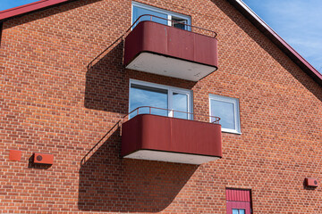 A little and comfortable residential building from red bricks and open balconies. European design and architecture. 