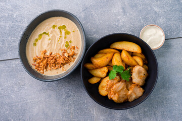 Lunch mushroom cream soup and fish with chips and sauce. Horizontal orientation, top view.