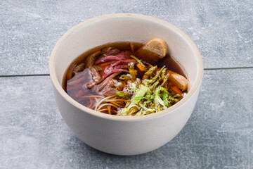 Japanese soup with beef, iceberg lettuce, udon noodles in a bowl