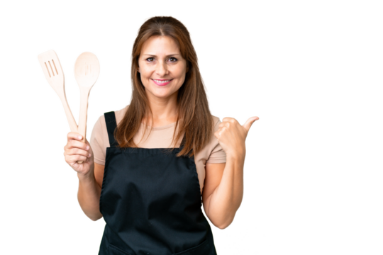 Middle age caucasian woman holding a rolling pin over isolated background pointing to the side to present a product