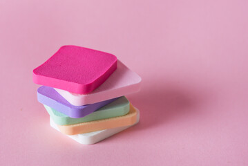 Stack of Colored Make Up Sponges on Pink Background with Copy Space