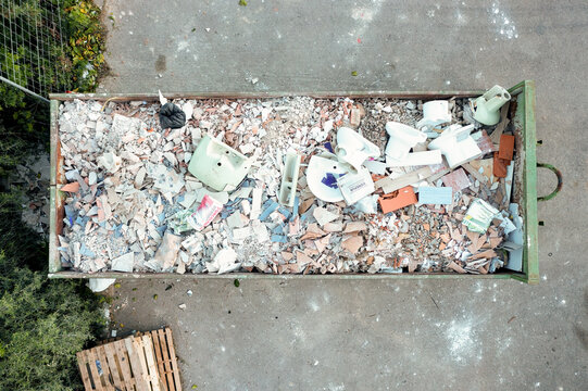 Huge heap of waste in a big overloaded dumpster waste metal container filled with construction waste