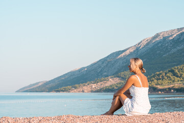 Girl in a white sundress on the beach