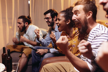 Football supporter fans friends watching soccer match on TV and celebrating goal or victory of national team. World championship and sports entertainment concept