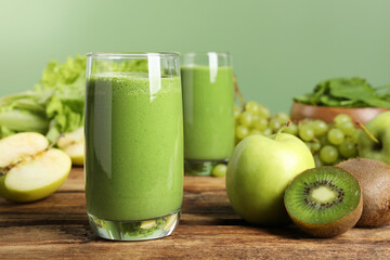 Green smoothie and fresh ingredients on wooden table